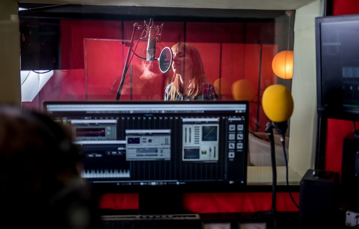 Female singer during vocal recording at music studio